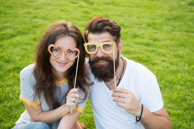 Sevgililer günün kutlu olsun. Aşık çift yeşil çim üzerinde parti gözlük ile gülümseyerek mutlu. Mutlu aile sopa üzerinde photobooth sahne tutan. Mutlu kutlamazevk