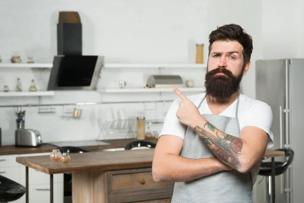 Welcome to his master class in culinary school. Happy master cook. Professional cook with long beard pointing finger. Master chef wearing cook uniform in kitchen. Taking time to master skills