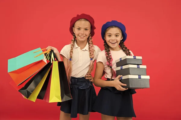 Bela compra. Meninas pequenas com sacos de compras e caixas. Crianças pequenas com sacos de papel e invólucros. Miúdos com sacos de papel e mochilas. Pequenos compradores. Fazer compras é um vício — Fotografia de Stock