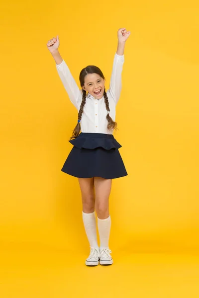 Terug naar school. Student Little Kid is dol op school. Emotioneel schoolmeisje. Vier de kennis dag. September tijd om te studeren. Meisje schattig leerling op gele achtergrond. School uniform en mode — Stockfoto