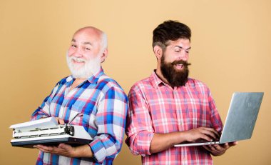 Yeni teknolojilerde ustalanın. Eski nesil. Dijital teknolojiler. Modern yaşam ve geçmişin kalıntıları. Daktilove hipster dizüstü bilgisayar ile kıdemli adam. Teknoloji savaşı. Erkekler yazma cihazları iş