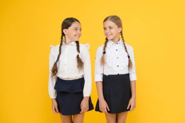 neşeli öğrenciler. sarı arka planda küçük kızlar. dostluk ve kardeşlik. En iyi dostlar. çocuk resmi moda. Yurtdışında eğitim. akıllı görünümlü çocuklar. okul arkadaşları. üniformalı mutlu çocuklar