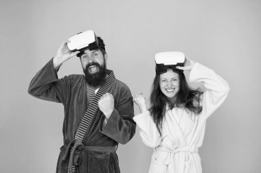 Erkek ve kadın VR 'ı keşfediyor. VR teknolojisi ve gelecek. VR iletişimi. Heyecan verici izlenimler. Sanal gerçeklikten uyanış. Bornozlu çift VR gözlük takıyor. Bilinçli uyanış. Gerçeğe dön.