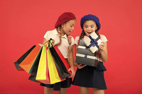 ¿Qué hay ahí? Niños pequeños con bolsas de papel y envolturas después de comprar. Niños pequeños con bolsas de papel y paquetes. Pequeños compradores. Chicas pequeñas con bolsas de compras y cajas. Compras es una adicción — Foto de Stock