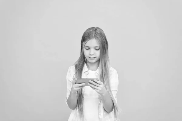 Mobila gadget beroende. Flicka lilla barnet ler hålla smartphone. Internetsurf och sociala nätverk. Problemet med ungdomar. Mobiltelefon och Internetberoende. Beroende av internet online spel — Stockfoto