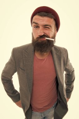 Adam acımasız sakallı hippi vagabond duman sigara gibi giyinmiş. Acımasız alışkanlıkları ve yaşam tarzı, sürtük. Hipster acımasız sakallı tütün sigara içen. Acımasız tıraşsız adam izole beyaz arka plan Sigara