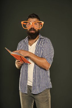 Ucube ve geek. Kitap okuma parti bardaklarda sakallı adam. Ders kitap nerd çalışma. Üniversite erkek öğrenci ders notları ile. Süslü gözlüklü kitap nerd