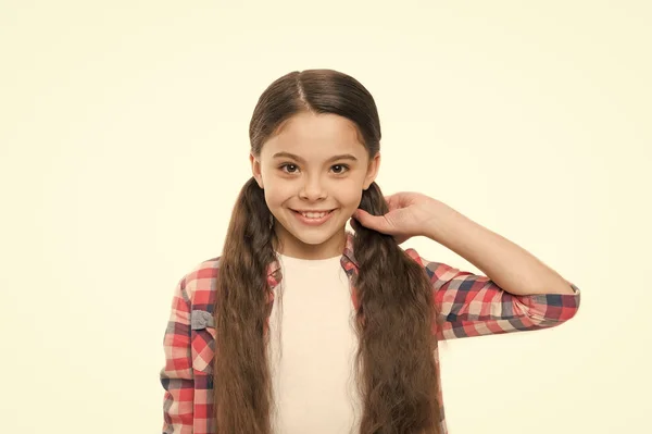 Gir hår en silkemyk perfeksjon. Pen jente med lang frisyre. Liten jente med stilig hestehale-frisyre. Et lite barn med brunette-hår. Liten hårmodell med vakkert utseende. Hårsalong for barn – stockfoto