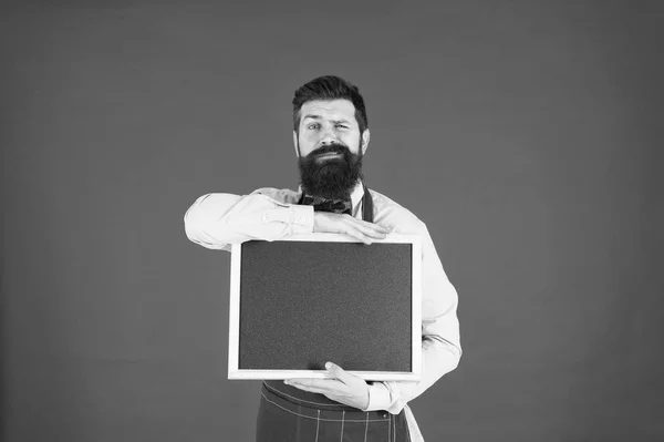 Professionele chef-kok. geweldige keuken. koken op recept. Welkom. Restaurant of café reclame. menukaart. Happy man chef-kok met blank Blackboard, kopieer ruimte. professionele bebaarde hipster Cook in schort — Stockfoto