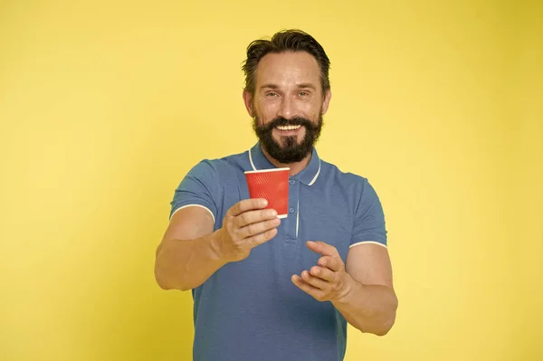 Recyclingfähige Kaffeetasse vorhanden. Hipster reifen Mann halten Pappkaffeetasse stehen gelben Hintergrund. Entspannte Kaffeepause. Trinken Sie es unterwegs. Bärtige Männer bevorzugen Kaffee zum Mitnehmen. Ökologischer Lebensstil und Recycling — Stockfoto