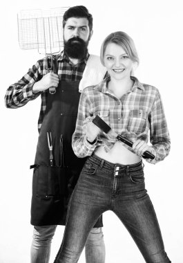 Arka Bahçe Barbekü partisi. Birlikte yemek. Temel Barbekü yemekleri. Sakallı hippi ve kız mutfak ızgara aletleri beyaz arka plan tutun. Piknik ve barbekü. Aile Barbekü için hazırlanıyor