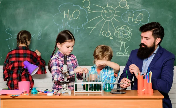 Wissenschaft ist immer die Lösung. Experiment Schulchemie. Kindern Chemie erklären. Faszinierender Chemieunterricht. Mann bärtige Lehrer und Schüler mit Reagenzgläsern im Klassenzimmer. Reaktion beobachten — Stockfoto