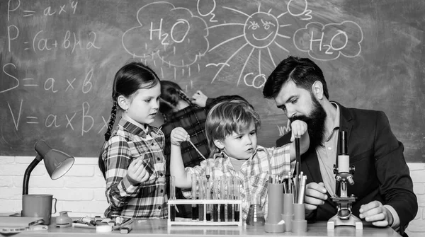 Φοιτητές που κάνουν επιστημονικά πειράματα με μικροσκόπιο στο εργαστήριο. Επιστήμονας σχολιαρόπαιδων. Χαρούμενα παιδιά δασκάλα. Πίσω στο σχολείο. Μικρά παιδιά μαθαίνουν χημεία στο σχολικό εργαστήριο — Φωτογραφία Αρχείου