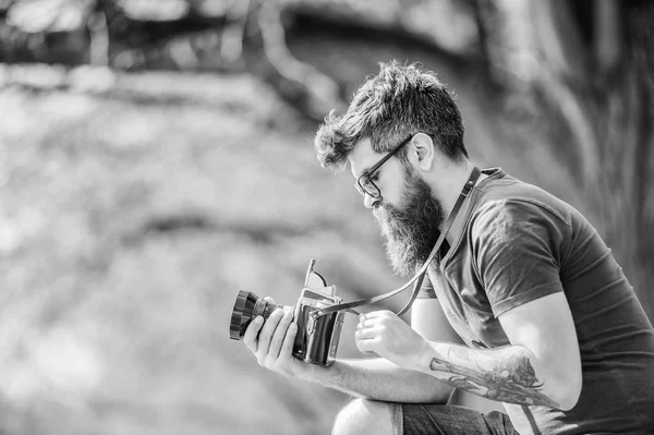 Utomhus foto utrustning. Hipster man i solglasögon. Brutal fotograf med kamera. Mogen hipster med skägg. Skäggiga mannen. Foto av naturen. reporter eller journalist. Njuter av sin arbetsdag — Stockfoto