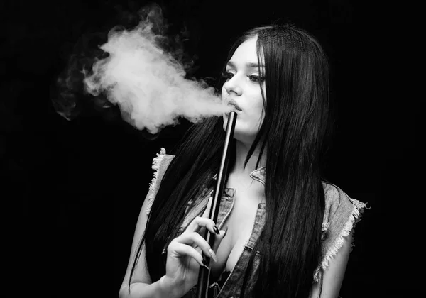 Hookah bar. Electronic cigarette. Fashion girl vaping. White cloud of smoke. Vaping is sexy. Nicotine addiction. Glamorous brunette smoking vaping device black background. Girl vaping. Rest and relax