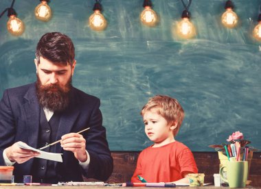 Çocuk ve meşgul yüz boyama, resim öğretmeni. Öğretmen sakallı, çizim arka plan kara tahta sınıf, küçük oğlu yakınındaki, takılmak iken Peder. Sanat ders kavramı