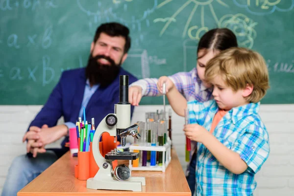 students doing science experiments with microscope in lab. back to school. school kids scientist study science. happy children. Little kids learning chemistry in school laboratory. Discovering cure