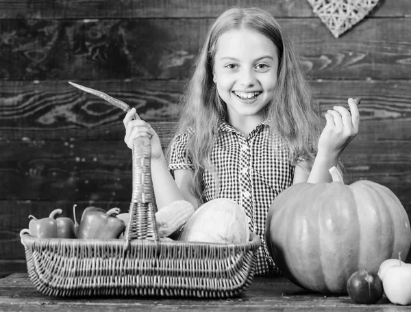 Kind meisje geniet van leven op de boerderij. Organische tuinieren. Kid boer met houten achtergrond van de oogst. Groeien van uw eigen biologisch voedsel. Meisje kind op boerderij markt met biologische groenten. Oogstfeest concept — Stockfoto
