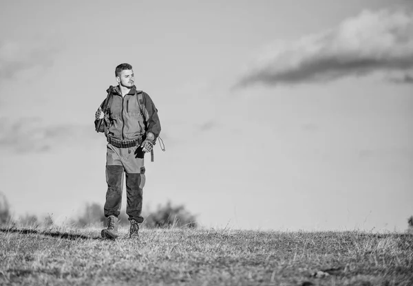 A tapasztalat és a gyakorlat sikervadászatot kölcsönöz. Fegyverre vagy puskára vadászik. Vadászhobbi. A természetet vadászta. Férfi hobbiaktivitás. Man vadász hordoz puska kék ég háttér — Stock Fotó