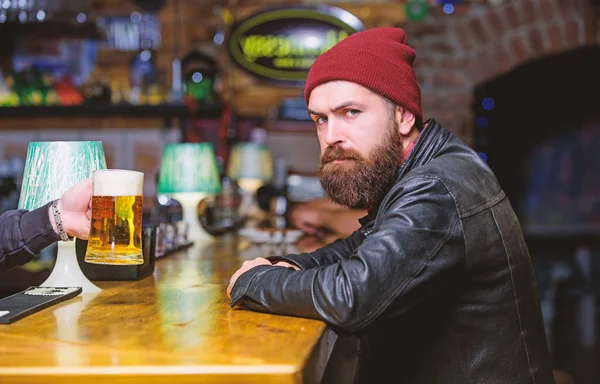 Bar is relaxing place to have drink and relax. Man with beard spend leisure in dark bar. Brutal lonely hipster. Hipster relaxing at bar. Brutal hipster bearded man sit at bar counter. Friday evening