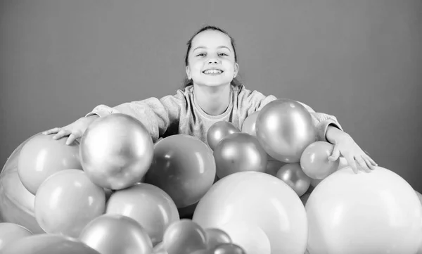 Balloons theme party. Girl between air balloons. Birthday party. Childrens day. Carefree childhood. All those balloons for me. Happiness positive emotions. Obsessed with air balloons. Having fun