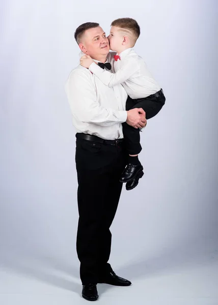 Hijo pequeño siguiendo el ejemplo de los padres de un hombre noble. Vacaciones familiares. Relaciones de padre e hijo. La educación de los caballeros. Traje de ropa formal de padre e hijo. Crecer caballero. La educación de los caballeros —  Fotos de Stock