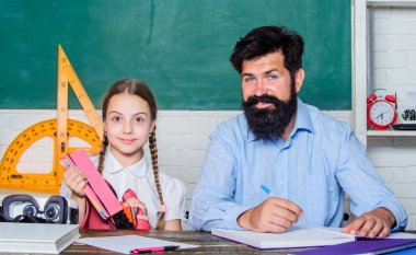 bilgi günü. Evde eğitim. özel ders. sınıfta sakallı öğretmen adam ile küçük kız çocuk. baba ile kızı çalışma. Öğretmenler günü. Okula geri dön. Özel öğretmenlik. Çok çalışmak