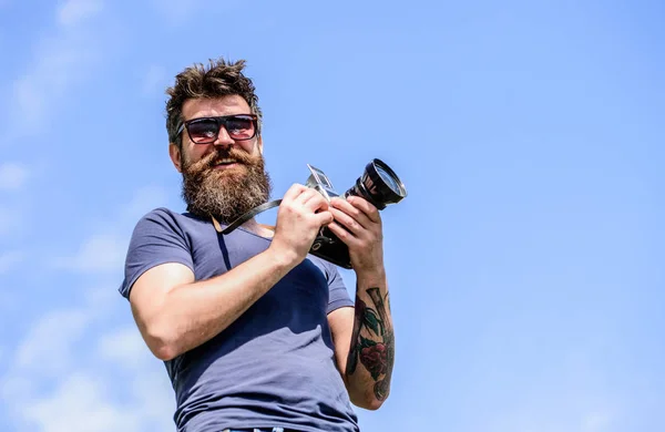 Un fotógrafo exitoso. foto de la naturaleza. reportero o periodista. fotógrafo brutal con cámara. hombre hipster en gafas de sol. equipos fotográficos retro. Hipster maduro con barba. Hombre barbudo —  Fotos de Stock