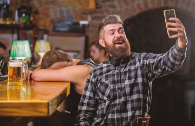 Alarak selfie kavramı. Çevrimiçi iletişim. Selfie arkadaşlar sosyal ağlara göndermek. Adam Bar bira içiyor. Harika akşam barda hatırlamak selfie fotoğraf çekmek. Adam hipster tutun smartphone sakallı
