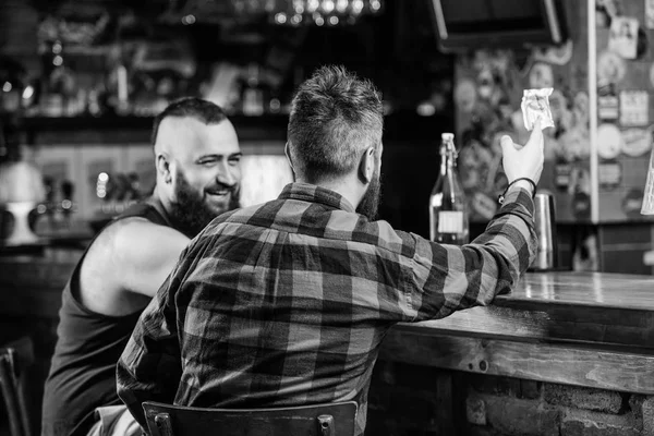 Friday relaxation in bar. Friends relaxing in pub. Hipster brutal bearded man spend leisure with friend at bar counter. Order drinks at bar counter. Men relaxing at bar. Friendship and leisure
