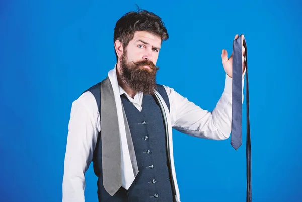 For formal occasions choose solid colored tie that is darker than your shirt. Match colors. Man bearded hipster hold few neckties on blue background. Guy with beard choosing necktie. Perfect necktie — Stock Photo, Image