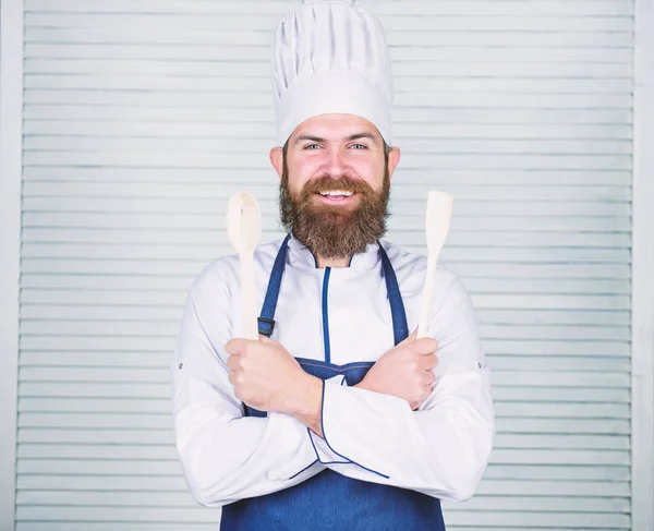 いくつかのスパイスを追加します。コック帽子とエプロンでひげを持つ男は、調理器具を保持します。専門職としての料理。ヒップスターは髭シェフ ホールド木のスプーンです。キッチン用品、料理の概念。味を試すことができます。 — ストック写真