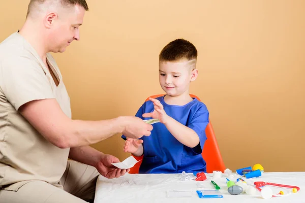Medicine and health. happy child with father with stethoscope. small boy with dad in hospital. father and son in uniform. family doctor. trust and values. cool father play with kid. father doctor — Stock Photo, Image