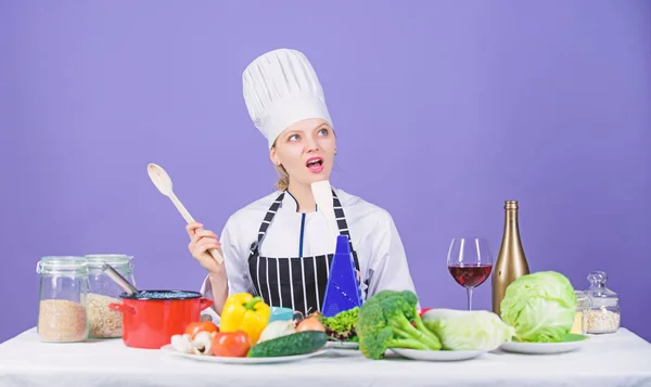 Matlagning är hennes hobby. Matlagning hälsosam mat. Flicka i hatt och förkläde. Kvinna kock Matlagning hälsosam mat. Färska grönsaker ingredienser för matlagning måltid. Läckra recept koncept. Gourmet huvudrätt recept — Stockfoto