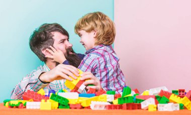 Köklerimize geri dönelim. çocuk gelişimi. renkli yapıcı ile ev bina. mutlu aile eğlence. baba ve oğul oyun oynar. Babamla birlikte oynayan küçük bir çocuk. kopya alanı. kucaklamalar en iyisidir