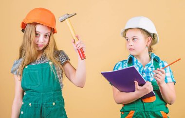 Kasklı çekiçli küçük çocuklar. İşçi bayramı. 1 mayıs. mutlu çocuklar. Gelecekteki kariyeri. Foreman müfettişi. Onarım. küçük kızlar atölyede birlikte tamir. Onarım dükkanında zor bir günün ardından yorgun hissetmek