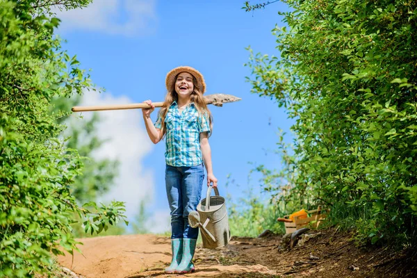 Menina criança segurar pá regando lata. Lista de verificação de jardinagem Primavera. Ajudante. Ferramentas de rega que irão resolver problemas de quintal seco. Rosa removível permite fluxo moderado. Dicas de jardinagem. Jardinagem de primavera — Fotografia de Stock