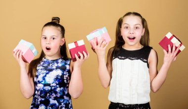 Kızlar sevimli doğum günü kutlamak. Çocuklar mutlu doğum günü hediyeleri seviyor. Alışveriş ve tatiller. Kız kardeşler hediyelerin tadını çıkarır. Çocuklar hediye kutuları bej arka plan tutun. Mutlu günler. Çocuk kızlar hediye memnun