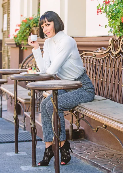 Conceito de sobremesa. Mulher atraente morena elegante desfrutar de sobremesa e café café terraço fundo. Tempo agradável e relaxamento. Lanche delicioso e gourmet. Menina relaxar café com café e sobremesa — Fotografia de Stock