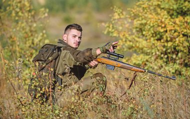 Hunter tüfek tutun. Adam Kamuflaj giysileri doğa arka plan giymek. Av izni. Sakallı ciddi avcı eğlence avcılık harcamak. Profesyoneller için avcılık ekipmanları. Avcılık acımasız erkeksi hobi