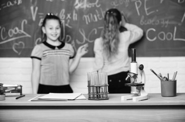 Mikroskop ve test tüpleri masada. Kimyasal reaksiyonlar. Kimya okumayı ilginç hale getir. Kimya dersinde tebeşir tahtasında öğrenci. Eğitici deney konsepti. Kızlar sınıf arkadaşları kimya eğitimi