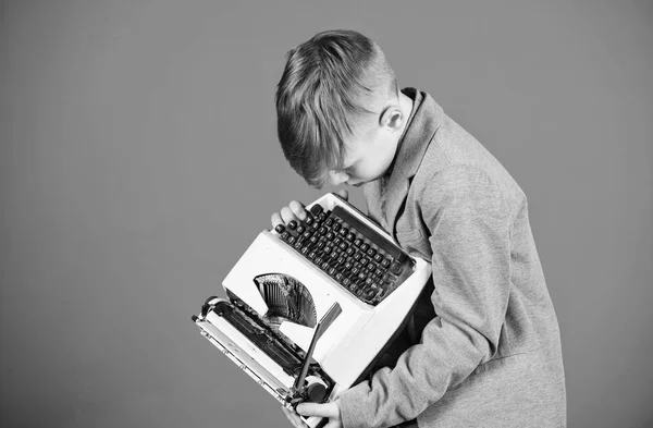 Retro and vintage. Yard sale. Retrospective study. Boy hold retro typewriter on blue background. What to do with this thing. Out of date. I need modern gadget instead this retro. Outdated gadget