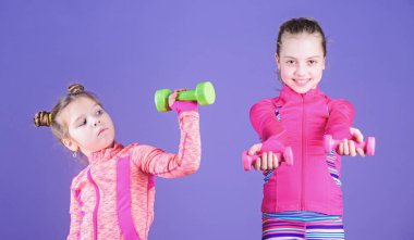 Güç ve enerji. Küçük çocuklar fiziksel fitness geliştirmek. Şirin kız spor salonu fitness egzersizleri dumbbells ile yapıyor. Küçük kız fitness eğitimi ağırlıkları ile keyfini çıkarın. Spor ve fitness çocuklar için