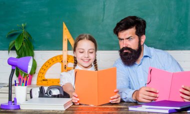 Çalışmaya konsantre oldun. sınıfta sakallı öğretmen adam ile küçük kız çocuk. baba ile kızı çalışma. Öğretmenler günü. Okula geri dön. Özel öğretmenlik. Bilgi. Evde eğitim. özel ders