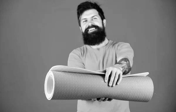 Man bearded athlete hold fitness mat. Fitness and stretching. Having good stretch. Athlete yoga coach motivated for training. Yoga class concept. Yoga as hobby and sport. Practicing yoga every day