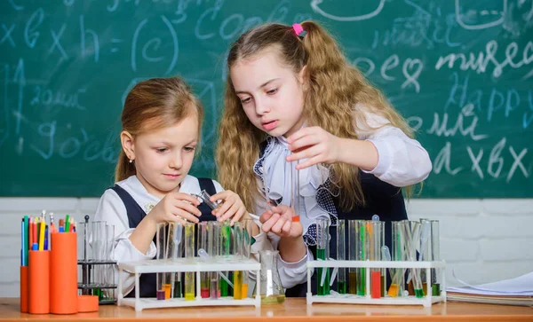 Análisis químico y reacción de observación. Equipo escolar para laboratorio. Chicas en la clase de química escolar. Compañeros de laboratorio. Niños ocupados con el experimento. Tubos de ensayo con sustancias coloridas — Foto de Stock