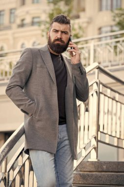 İrtibatı koparmayalım. Adam ciddi iş adamı tutun cep telefonu kentsel arka plan sakallı. Hipster smartphone arama ortağı. Adam mobil telefon smartphone. Mobil arama kavramı. Önemli telefon konuşma