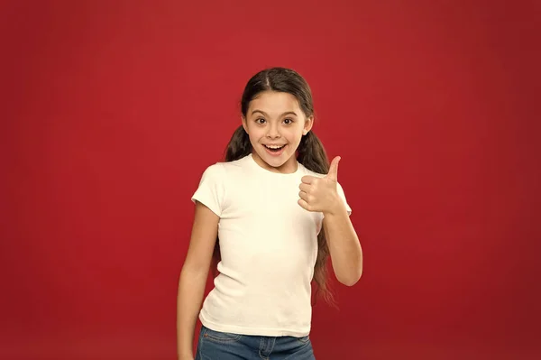 Aproveite cada momento. Menina feliz criança com cabelos longos no fundo vermelho. Felicidade e alegria. Emoções positivas. Cuidados infantis e educação. Kid sorrindo rosto bonito viver uma vida feliz despreocupada. Jovens e livres — Fotografia de Stock