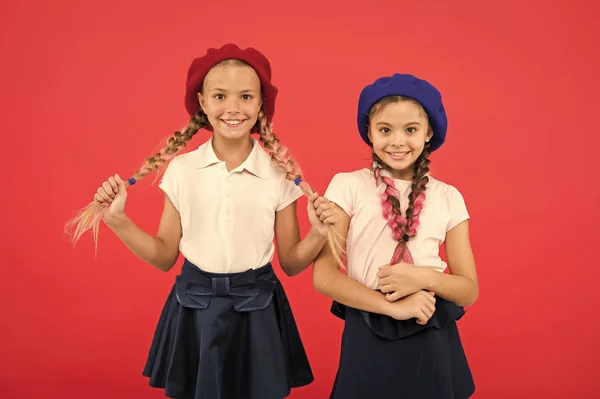 Cute and stylish. Little kids wearing stylish french berets. French style girls. Cute girls having the same hairstyle. Small children with long hair plaits. Fashion girls with tied hair into braids — Stock Photo, Image