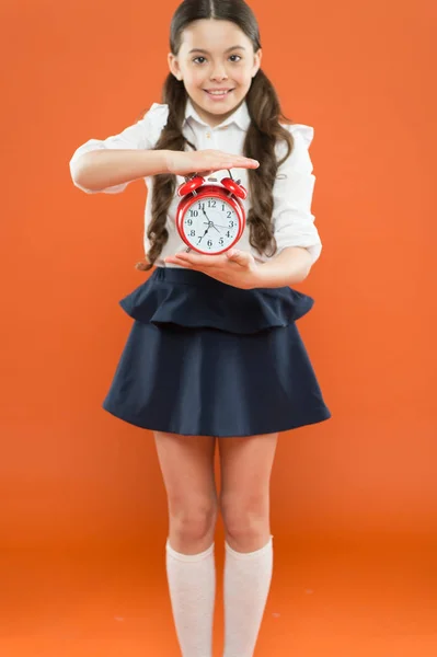 Primeiro dia de Outono. horário diário de rotina. estudante e despertador retro. Hora da escola. Hora de ir para a escola. Educação infantil. Dia do conhecimento. Menina feliz segurar despertador contando para a hora do almoço — Fotografia de Stock